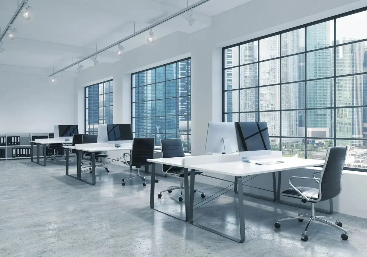 Empty Office Space Tables with computers in front of large windows