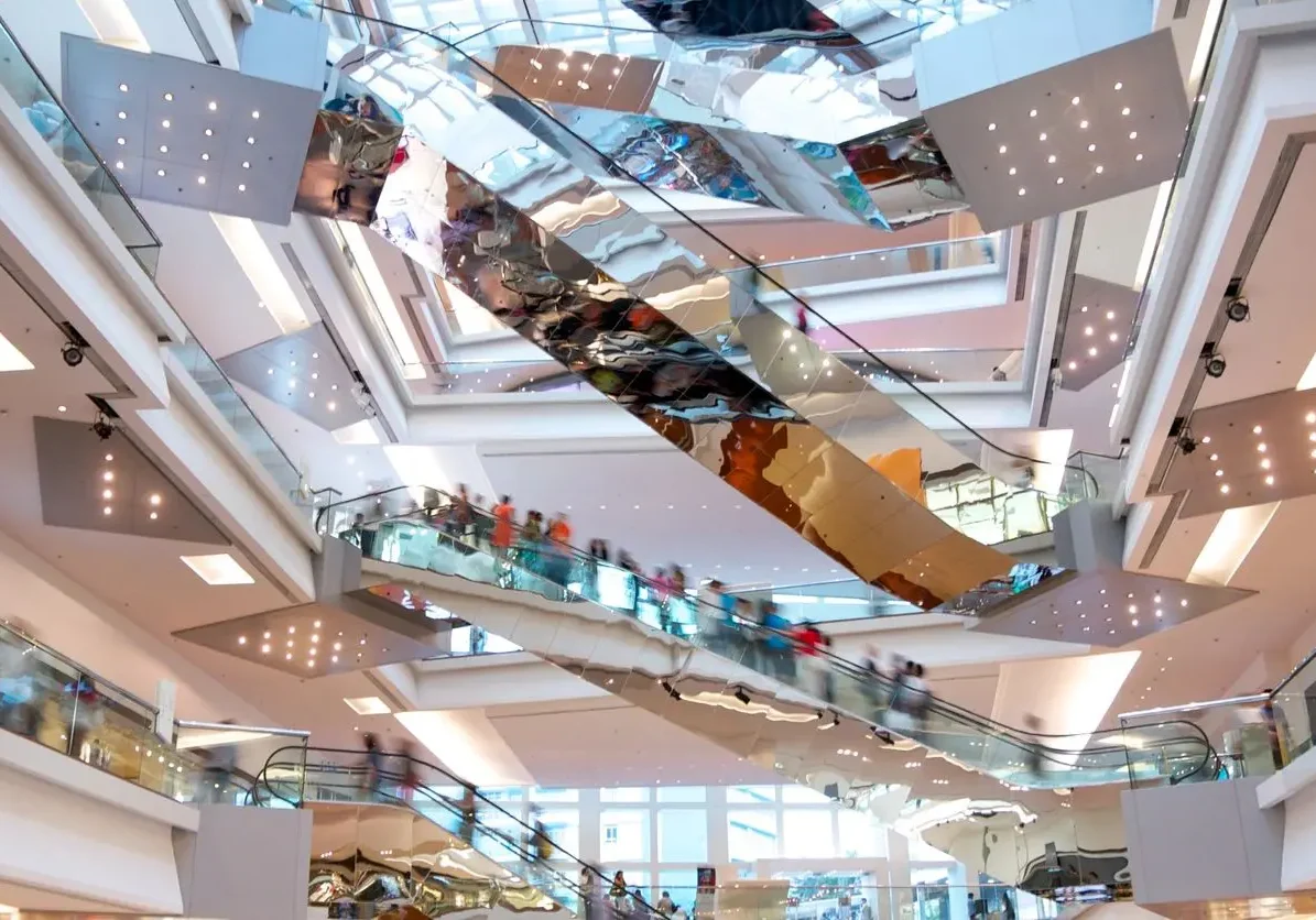 View from underneath mirrored escalators in bustling retail mall